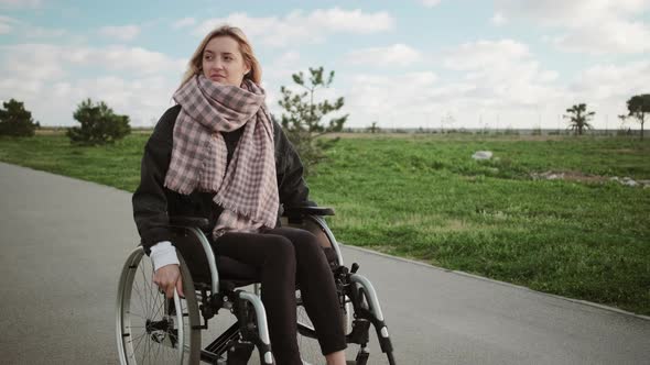 Lonely Disabled Woman in Wheelchair Outdoors alt