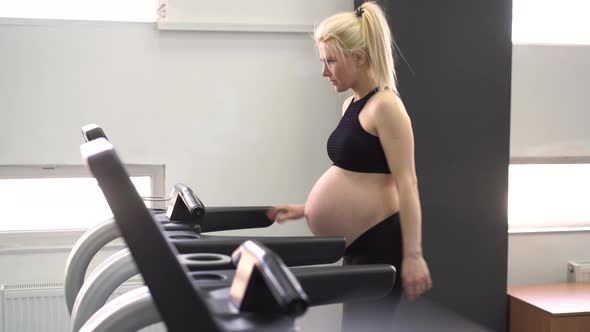 Pregnant Woman Training Treadmill Machine in Gym Cardio Exercises on Running Simulator alt