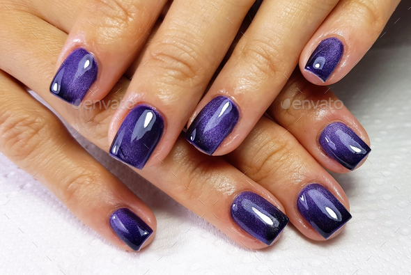 Top view shot of a woman with her modern gel art manicure on a soft fabric surface