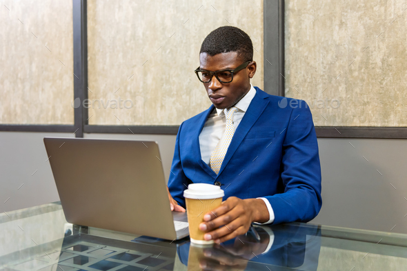 Black young businessman working on laptop - Stock Photo - Images