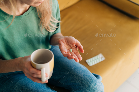 Close-up of a woman holding a pill in her palm. Copy spce - Stock Photo - Images