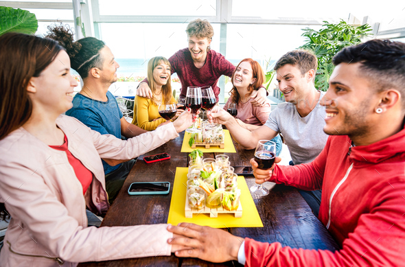 Happy young people having fun together drinking wine at penthouse on private home party - Stock Photo - Images