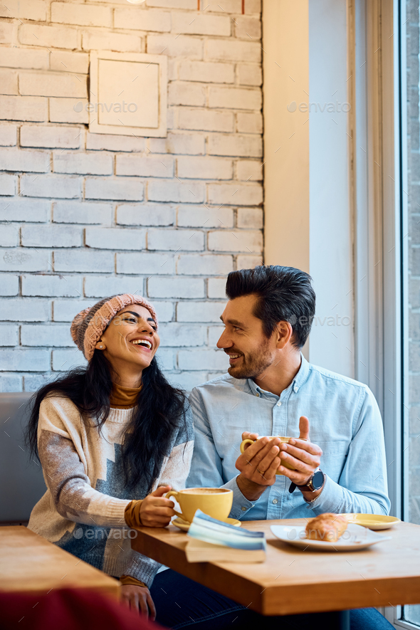 Happy couple having fun while talking and drinking coffee in a cafe. - Stock Photo - Images