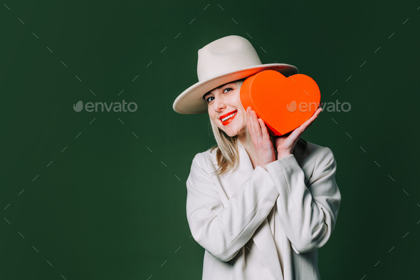 Stylish blond hair woman with gift box on green background - Stock Photo - Images