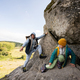 Father with son climbing big stone in hill. Pidkamin, Ukraine. - PhotoDune Item for Sale