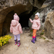 Two girls kids explore limestone stone cave at mountain in Pidkamin, Ukraine. - PhotoDune Item for Sale
