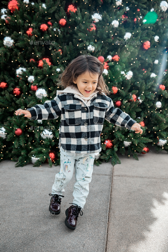 Lifestytle portrait of happy little toddler girl running near Christmas tree - Stock Photo - Images
