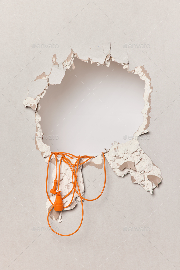 Destroyed plaster wall with extension cord. Process of reconstruction or repair. Electrical - Stock Photo - Images