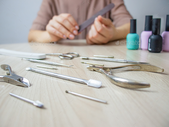 home manicure, woman saws her nails with a nail file