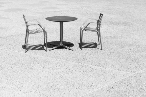Black and white photo of two chairs at an empty table, space for text. - Stock Photo - Images