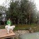 Woman with dog on pier near lake in pine forest - PhotoDune Item for Sale