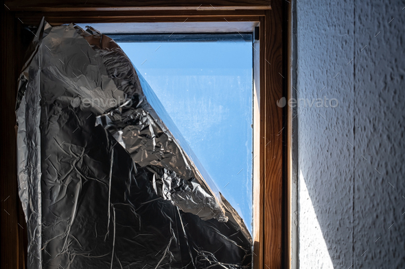 Window covered with foil to prevent sunlight from entering house during heat