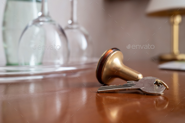 Key with a key fob from the hotel room lies on the table, against a blurred background - Stock Photo - Images