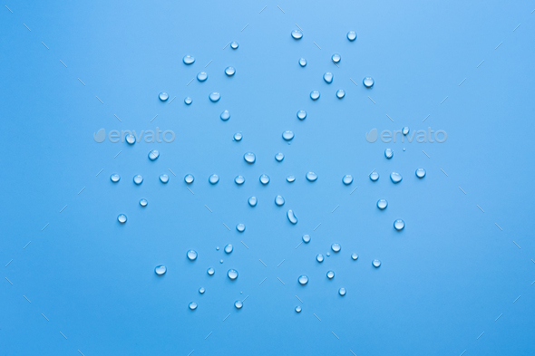 Snowflake from water drops on a blue background. Concept of thaw and snow melt - Stock Photo - Images