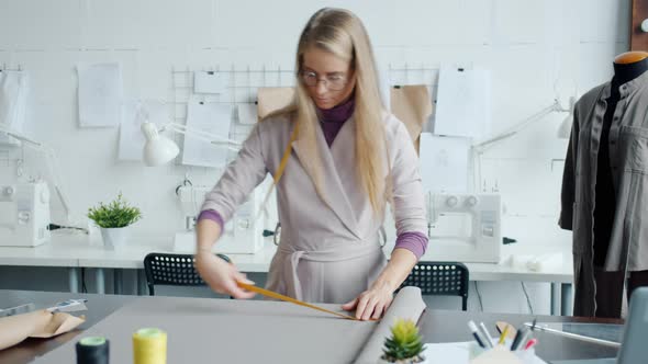 Portrait of Creative Female Tailor Choosing Material for New Garment alt