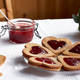 Heart shaped homemade cookies with strawberry jam on the table with white tablecloth. - PhotoDune Item for Sale