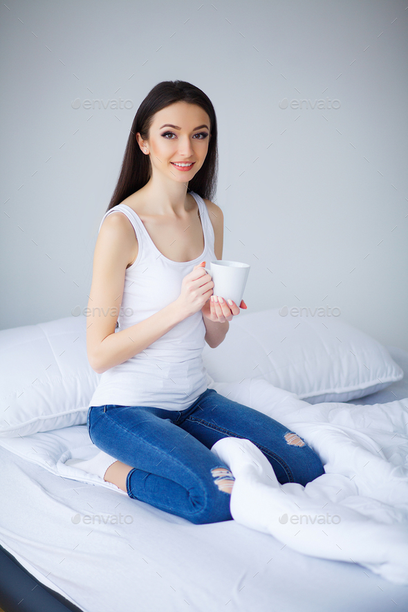 Smiling Woman With Fit Body And Beautiful Legs On White Bed Stock Photo by  maksymiv