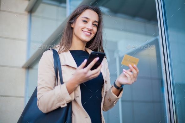 Woman Using Gold Credit card and Cellphone For Paying
