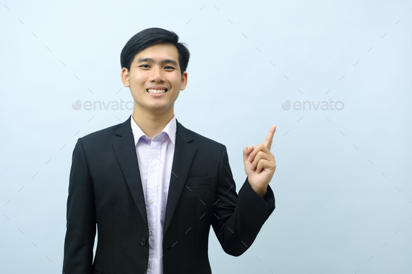 Portrait of businessman pointing and looking at camera. - Stock Photo - Images