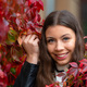 portrait of positive young woman posing in red autumn ivy wall outdoor - PhotoDune Item for Sale