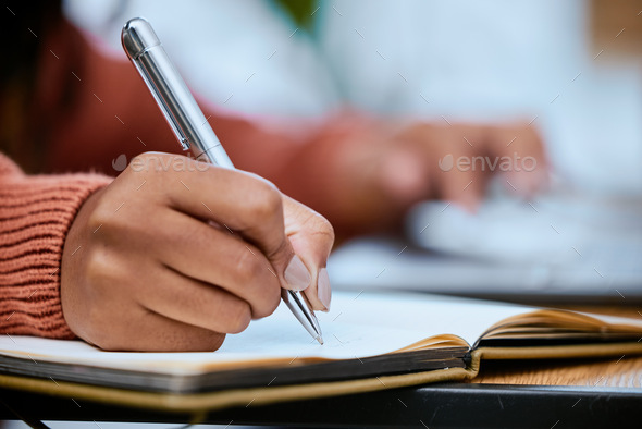 Student, writing and zoom of hand with notebook for studying, learning and notes in academic class.
