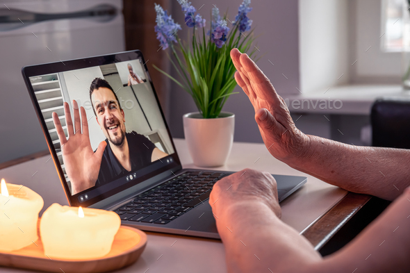 An old woman communicates with her son via video link through a laptop. - Stock Photo - Images
