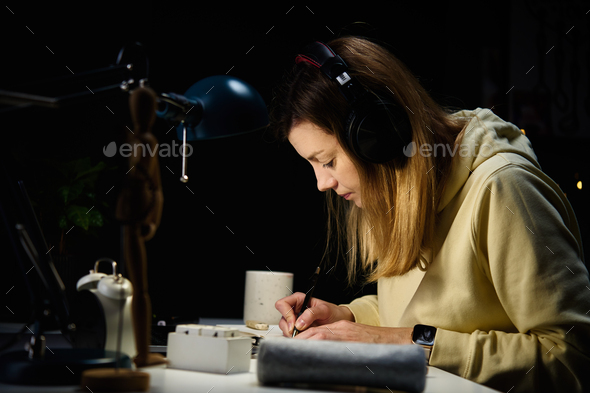 Woman at home workplace using laptop at night - Stock Photo - Images