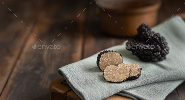 Whole and sliced black truffles mushroom on wooden board on green napkin, close up - Stock Photo - Images