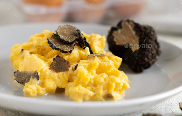 Scrambled eggs with fresh black truffles from Italy served in a plate close up, gourmet breakfast - Stock Photo - Images