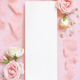 Blank paper card between pink roses and pink silk ribbons on pink top view, wedding mockup - PhotoDune Item for Sale