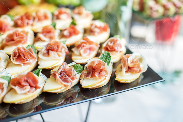 catering buffet table with snacks and appetizers. Set of canapés with jamon, bruschetta and cheese - Stock Photo - Images