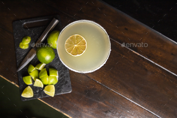 Still life with zenith plane of a margarita cocktail surrounded by pieces of lime