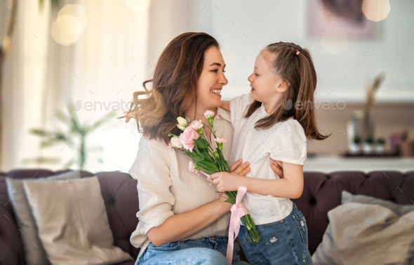 Daughter giving mother bouquet of flowers. - Stock Photo - Images