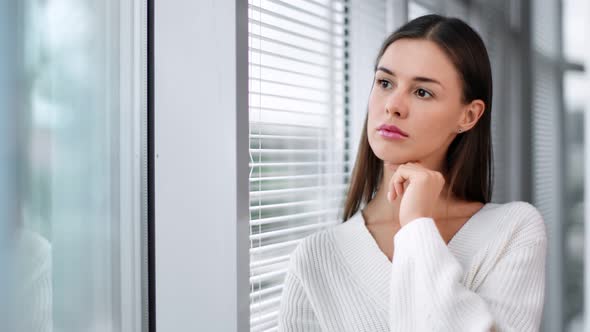 Pensive Business Woman Standing Near Window with Jalousie alt
