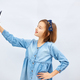 Smiling little girl in casual denim dress hold smartphone do selfie - PhotoDune Item for Sale