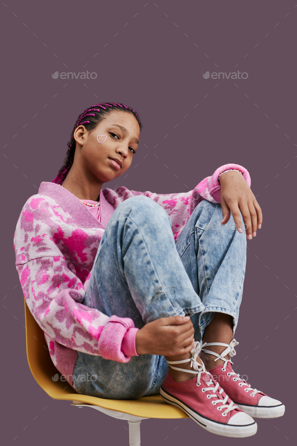 Black teenage girl wearing trendy casual clothes posing in pink - Stock Photo - Images