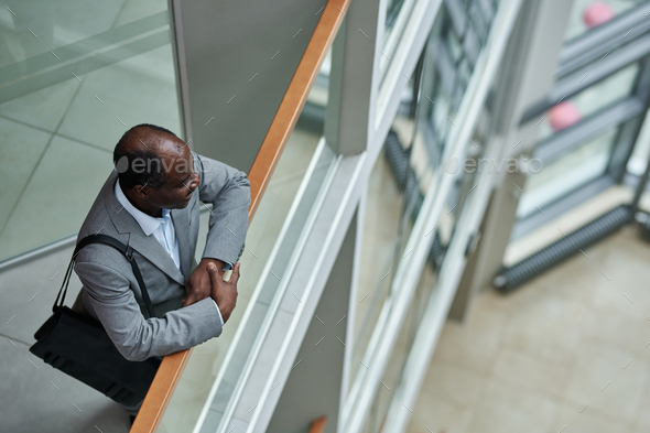 Above shot of mature African American broker with black handbag on shoulder - Stock Photo - Images