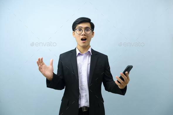 Portrait of surprised businessman holding mobile phone. - Stock Photo - Images