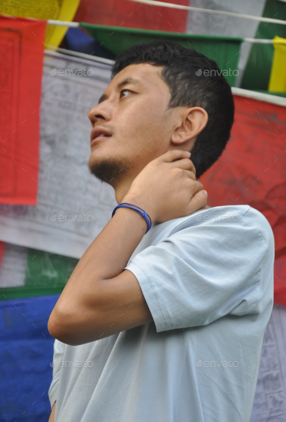 Closeup of a asian guy posing with hand behind neck looking sideways