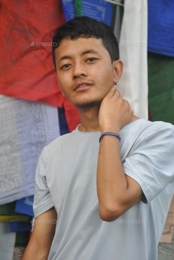 Photo of a asian guy posing with hand behind neck looking at camera