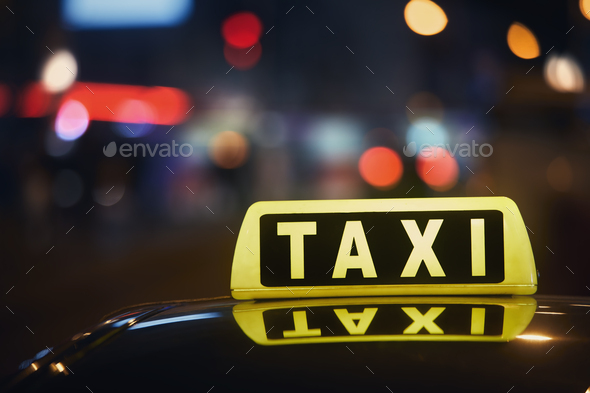 Close-up of taxi sign on car at night - Stock Photo - Images