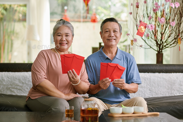 Senior Couple Showing Red Envelopes - Stock Photo - Images