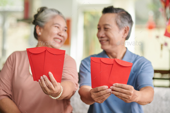 Positive Senior Couple with Red Envelopes - Stock Photo - Images