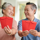 Positive Senior Couple with Red Envelopes - PhotoDune Item for Sale