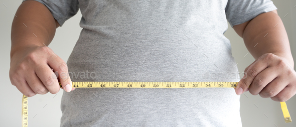 An obesity using measuring tape to show the real size. Stock Photo by  stockerthings