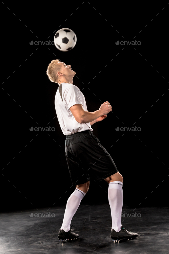 Soccer player bouncing a ball on his head Stock Photo by LightFieldStudios