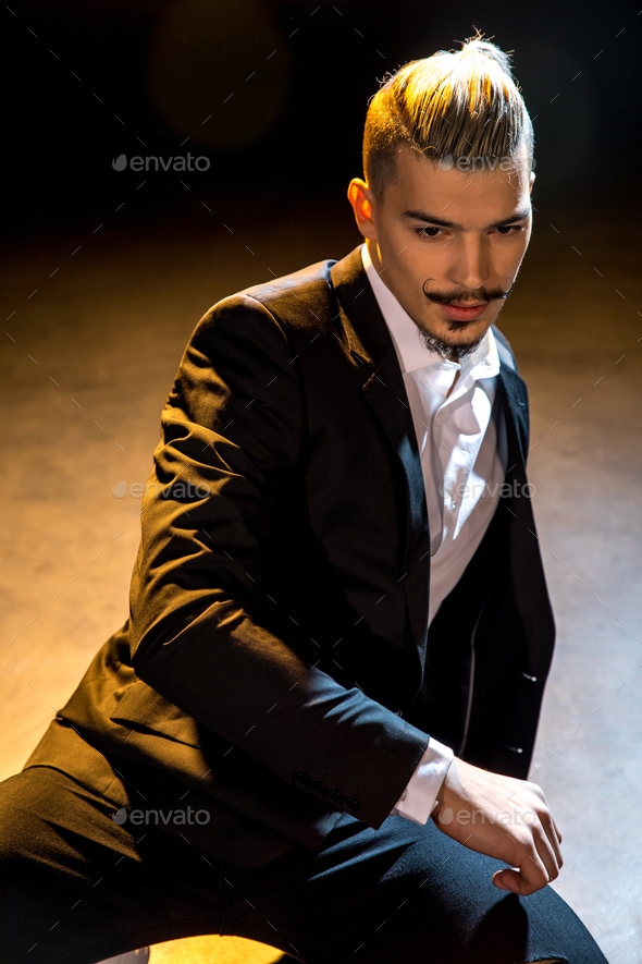 Handsome young man in suit dancing on floor Stock Photo by