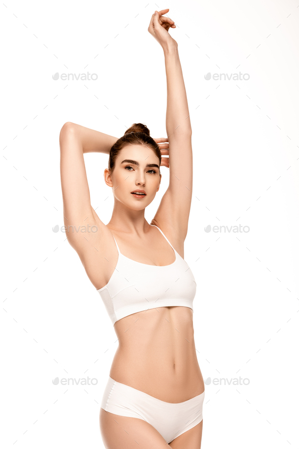 woman with perfect body in panties and top standing with hand above head  and looking at camera Stock Photo by LightFieldStudios