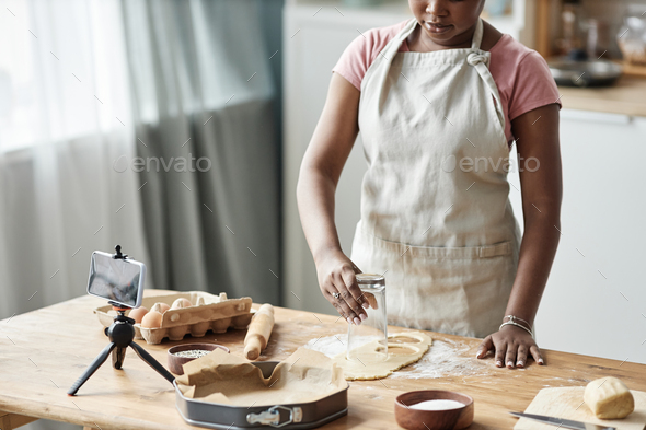 Cropped shot of black woman baking and recording livestream - Stock Photo - Images