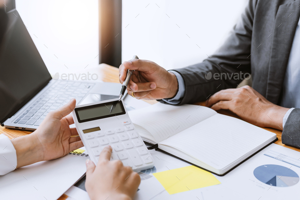 Close up of a business people with hand using a calculator to calculate business principles at meeti - Stock Photo - Images